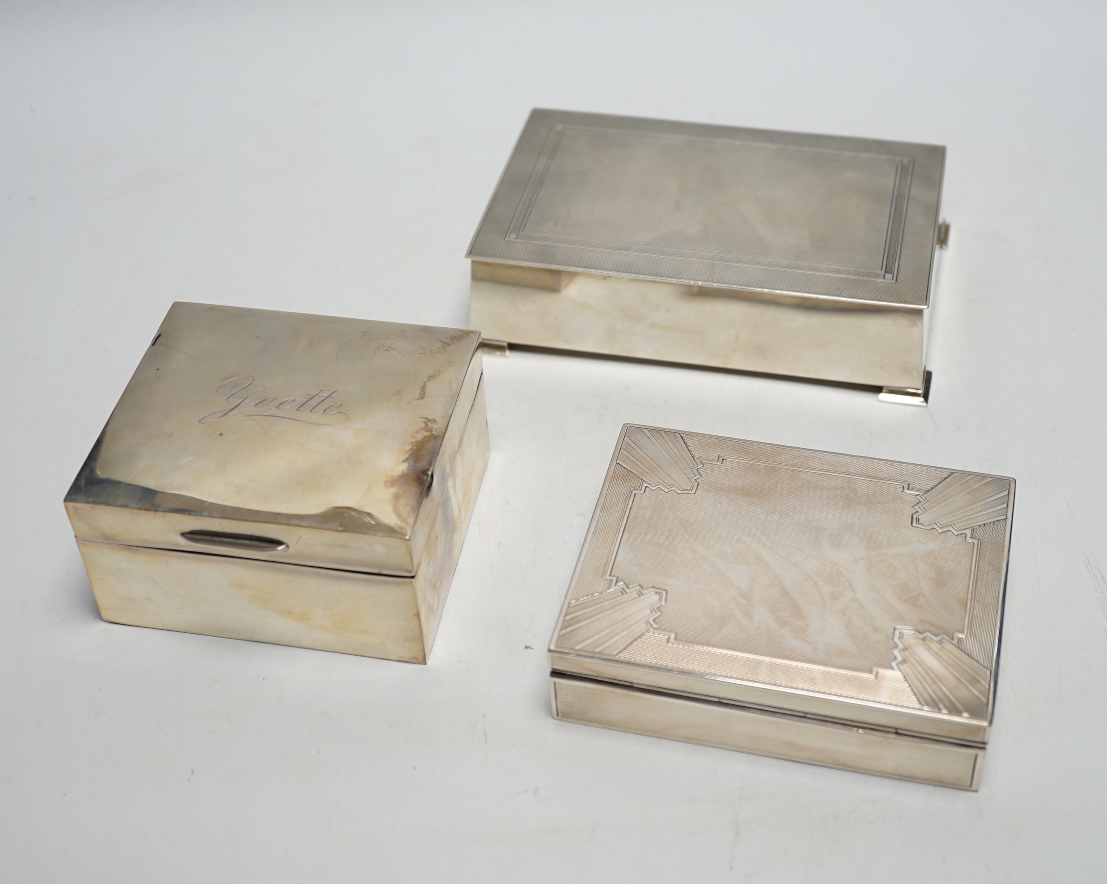 Three assorted silver mounted cigarette boxes including two 1930's, one by Goldsmiths & Silversmiths Co Ltd, largest 15.6cm.